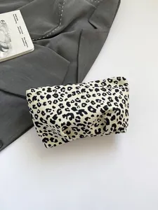 Vue détaillée d'une trousse à maquillage imprimé léopard sur un fond chic de mode