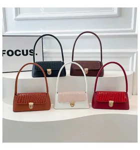 Detail of five assorted baguette bags featuring faux crocodile pattern and gold buckle