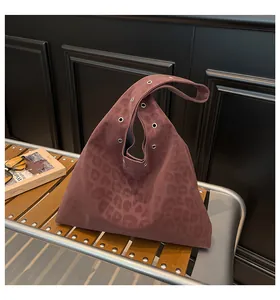 Detailed texture of burgundy leopard print tote bag with silver eyelets and suede finish