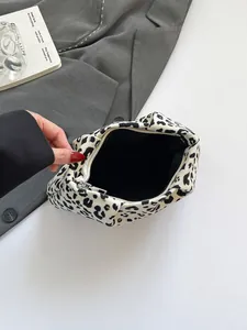 Trousse de maquillage léopard montrant la capacité intérieure et la doublure noire
