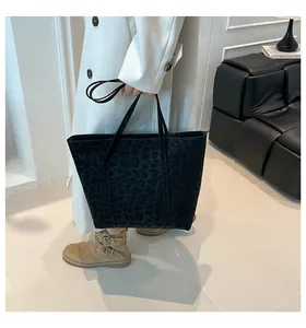 Detail of black leopard print tote bag in premium suede fabric with leather handles
