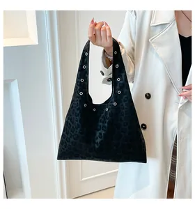 Detail view of black leopard print hobo bag featuring decorative silver metal eyelets
