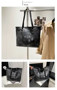 Close-up of black tote bag with checkerboard texture and circular embossed logo design