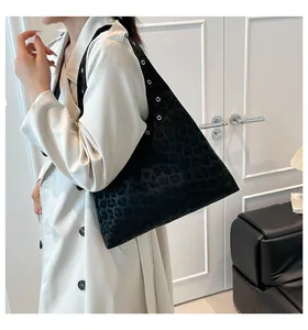 Detail of black leopard print suede tote with silver metal grommets on shoulder strap