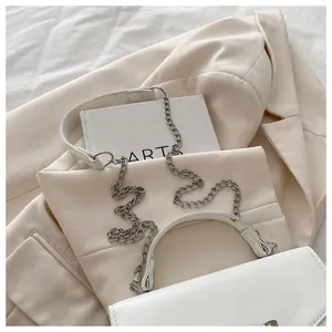Close-up of white leather handbag with silver chain strap and refined stitching details