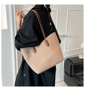 Detail of light beige tote bag with litchi grain texture and brown shoulder straps