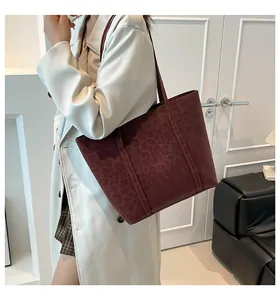 Dark red leopard print tote bag styled with a white trench coat in a modern setting