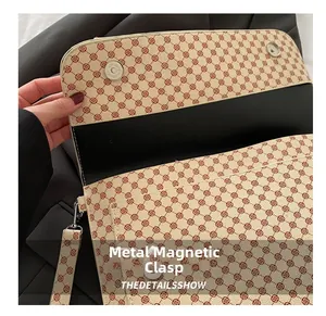 Détail de la boucle magnétique argentée et du motif floral sur la pochette rétro
