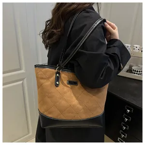 Detail of large tote bag showing brown suede quilting and black leather stitching