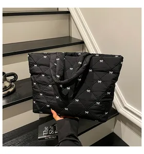 Nahaufnahme der schwarzen Stepptasche mit weißen Schleifenstickereien auf Treppen
