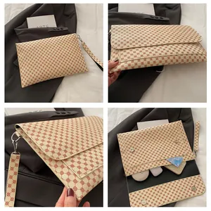 Vue détaillée de la pochette enveloppe crème à motifs circulaires avec dragonne