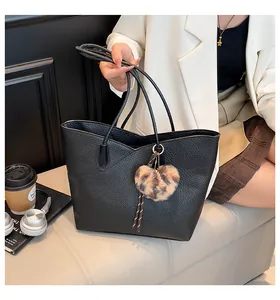 Detail of black tote bag with wavy top edge and leopard print heart puff charm