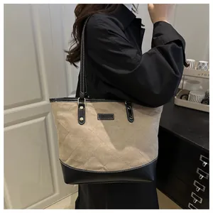Detail of the khaki quilted tote bag with black leather base and FASHION logo tag