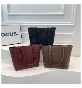 Three large leopard print tote bags in black, burgundy and brown suede textures