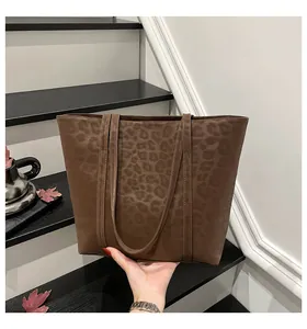 Close-up of a large leopard print tote bag in dark brown with matte suede texture