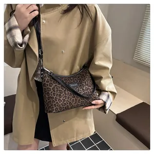 Detail der Vintage Schultertasche mit Leopardenmuster zum khakifarbenen Trenchcoat