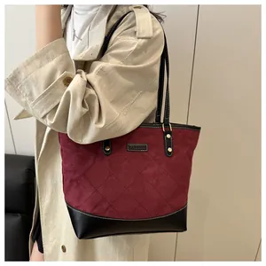 Detail of burgundy quilted tote bag with black leather patchwork and Fashion label