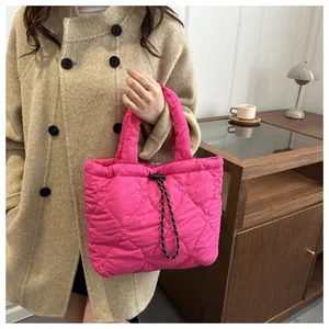 Detail of bright pink quilted tote bag with heart patterns and woven drawstring accents