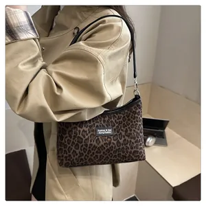 Nahaufnahme der Schultertasche mit Leopardenmuster, schwarzen Riemen und Silberbeschlägen