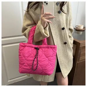 Detail of bright pink quilted tote bag with heart patterns and soft padded handles