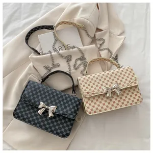 Detail view of stylish square crossbody bags with geometric patterns and bow buckles