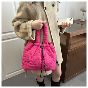 Detail of pink quilted tote bag with heart embroidery and black-and-white drawstrings