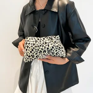 Pochette moderne à motif léopard en toile beige portée par un mannequin en studio minimaliste