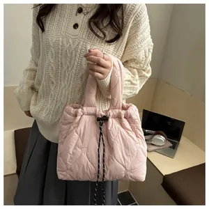 Detailed view of pink quilted tote bag with heart patterns and drawstring closure