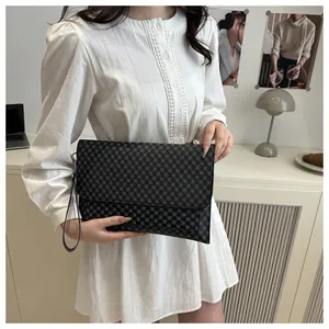 Détail du sac à main damier gris foncé avec rabat enveloppe et dragonne élégante