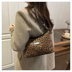 Detail der Vintage Schultertasche mit Leopardenmuster, schwarzem Riemen und Silberschnalle