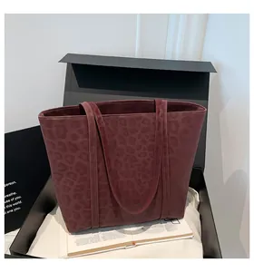 Close-up of a burgundy leopard print tote bag placed inside a premium gift box