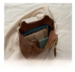 Macro view of brown leather tote bag interior showing large capacity for laptop and tablet