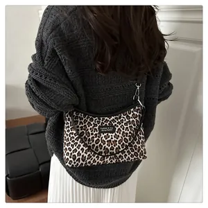 Nahaufnahme der Schultertasche mit Leopardenmuster, schwarzem Lederriemen und Metall