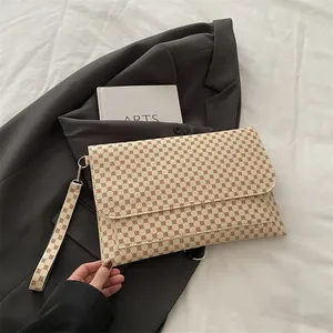 Détail d'un sac à main crème chic avec motifs géométriques et dragonne assortie de luxe