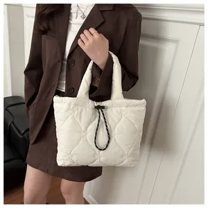 Detail of cream quilted tote bag with heart embroidery and stylish drawstring closure