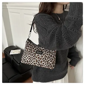 Detailansicht der Retro-Schultertasche mit Leopardenmuster, getragen von einem Model