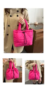 Detail of rose red quilted tote bag with heart patterns and black drawstring closure