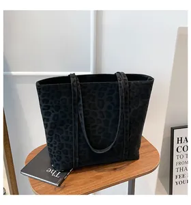 Close-up of the subtle leopard pattern texture on this black suede tote bag