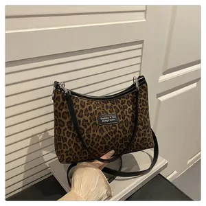 Detail der Vintage-Schultertasche mit Leopardenmuster, schwarzen Lederkanten und Silberbeschlag