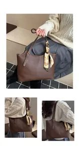 Detail of brown faux leather tote bag with white stitching and floral silk scarf accessory