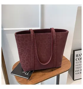 Close-up of burgundy leopard print tote bag with soft suede texture and twin straps