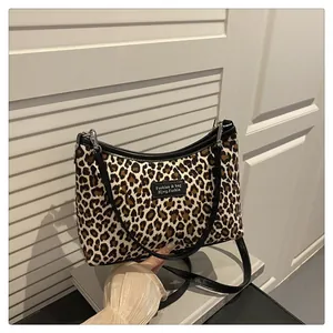 Detailaufnahme der Leoparden-Umhängetasche mit schwarzem Besatz und Lederriemen