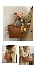 Detail of caramel leather tote bag handle decorated with a printed silk scarf and metal buckle