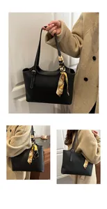 Detail of a black tote bag with white contrast stitching and a vintage print silk scarf