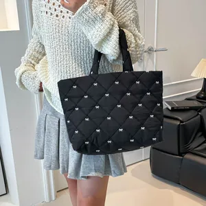 Gesteppte schwarze Tragetasche mit weißen Schleifen im geräumigen minimalistischen Stil