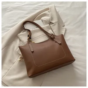 Close-up of caramel brown tote bag with white contrast stitching and decorative silk scarf