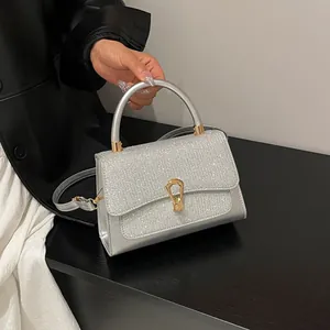 Silver glittering square handbag with metallic leather and golden horseshoe buckle