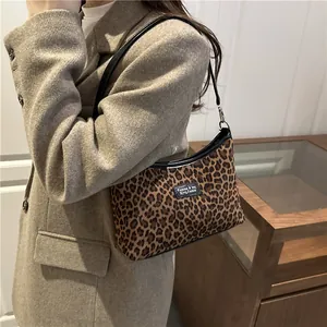 Retro Schultertasche mit Leopardenmuster und schwarzen Lederriemen am Model getragen