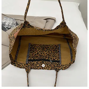 Detailed interior of leopard print canvas tote bag showing magnetic buckle and zip pocket