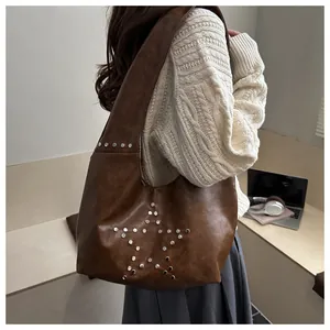 Dettaglio della borsa a tracolla retrò marrone scuro con decorazioni di borchie a stella